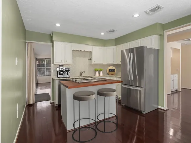 a kitchen with stainless steel appliances a refrigerator and wooden floor