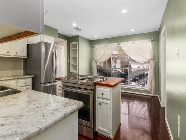 a kitchen with stainless steel appliances granite countertop a stove a refrigerator and a sink