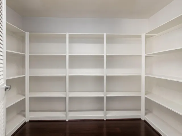a view of walk in closet with empty racks
