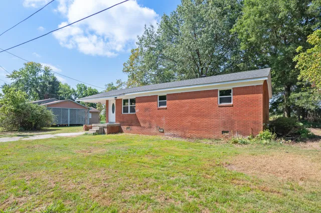 a front view of a house with a yard and trees
