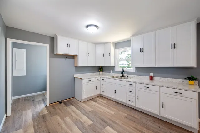 a kitchen with sink cabinets and wooden floor