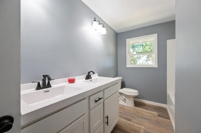 a bathroom with a sink toilet and a mirror