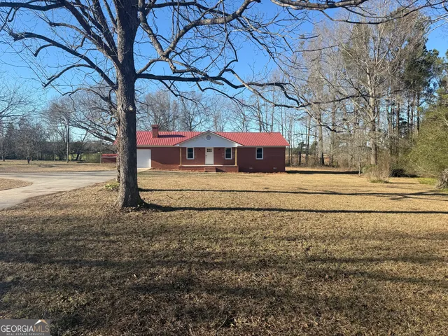 a view of dirt yard with a large tree