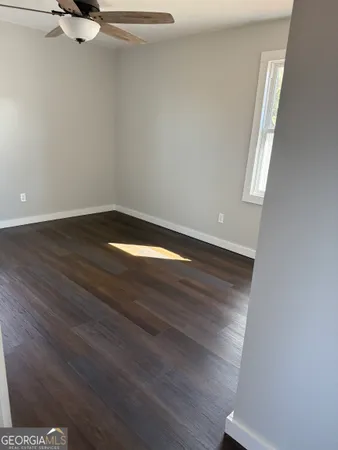 a view of an empty room with wooden floor