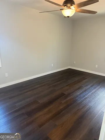 a view of a room with wooden floor and fan