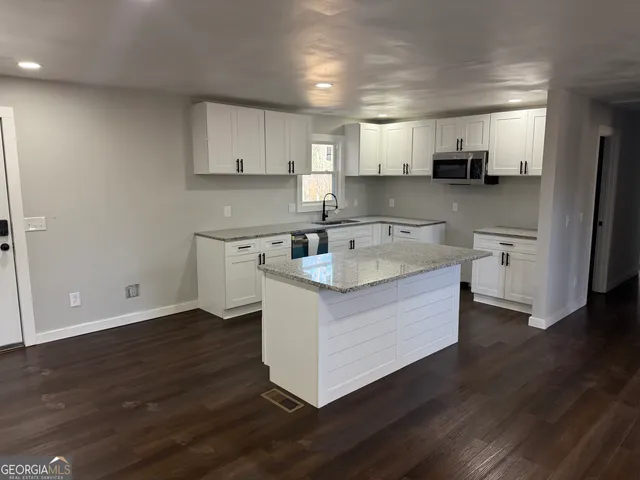 a kitchen with a sink cabinets and wooden floor