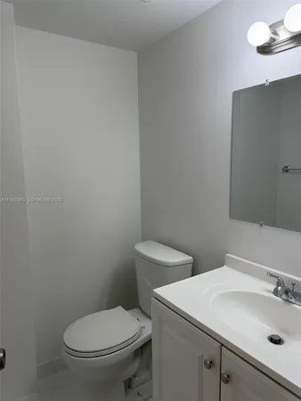 a white toilet sitting next to a bathroom sink