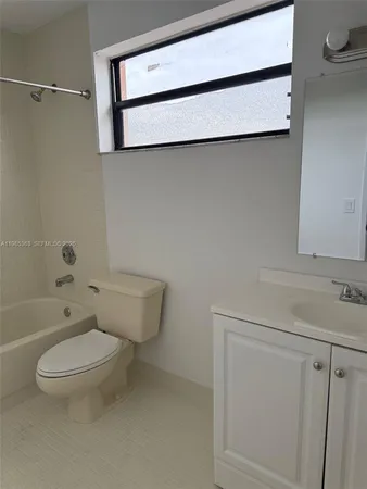 a white toilet sitting next to a bath tub