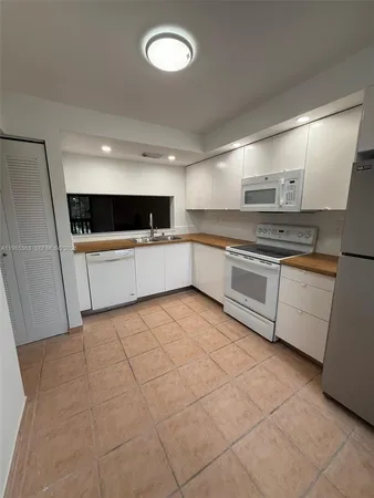 a large kitchen with cabinets and stainless steel appliances