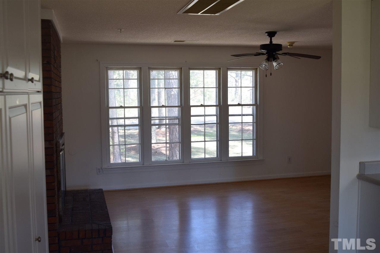 1513 Creech Road Garner, NC 27529 - Photo 3 of 10 an empty room with wooden floor and windows