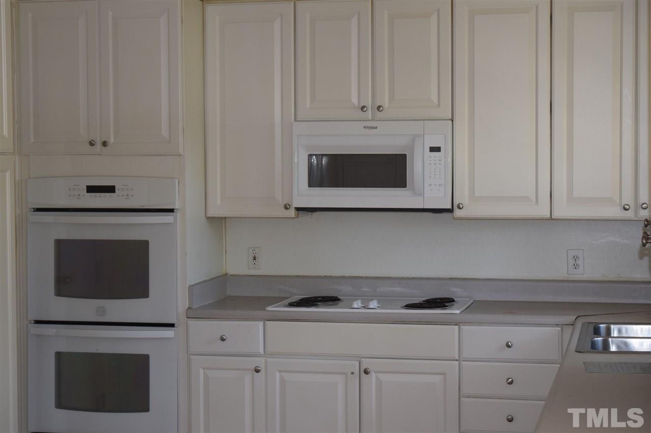 1513 Creech Road Garner, NC 27529 - Photo 4 of 10 a kitchen with white cabinets stainless steel appliances and sink