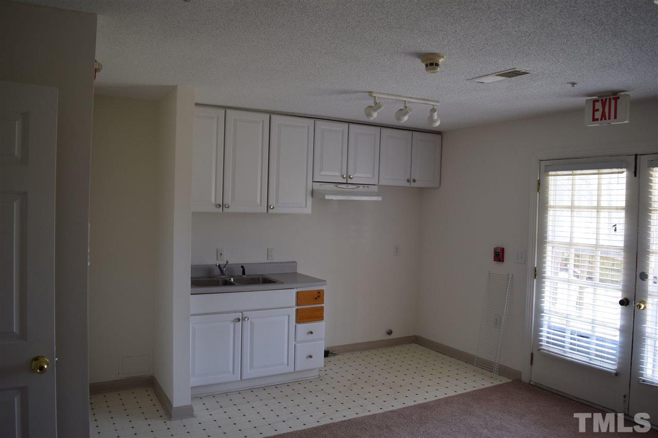 1513 Creech Road Garner, NC 27529 - Photo 7 of 10 a kitchen with white cabinets and window