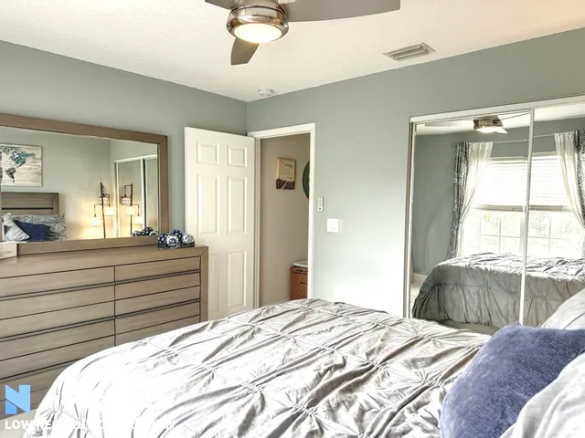 a bed room with a bed mirror and a window