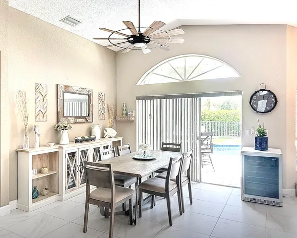 a dining room with wooden floor a chandelier a wooden table and chairs