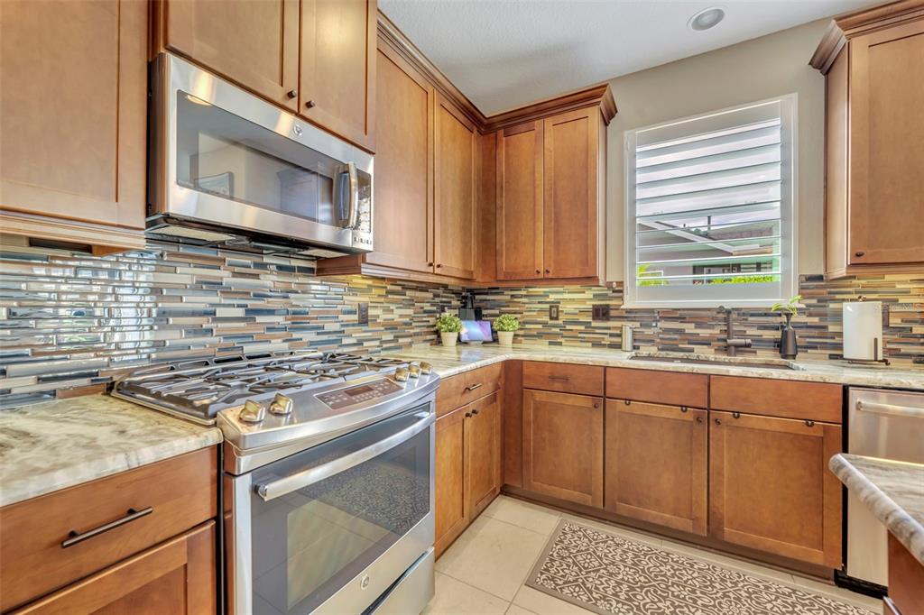 115 Bayou Bend Road Groveland, FL 34736 - Photo 11 of 47 a kitchen with stainless steel appliances granite countertop a sink stove and microwave