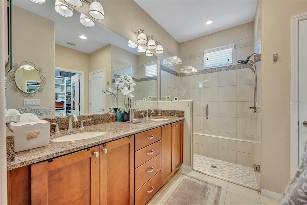 115 Bayou Bend Road Groveland, FL 34736 - Photo 26 of 47 a spacious bathroom with a granite countertop sink a mirror a shower and a bathtub