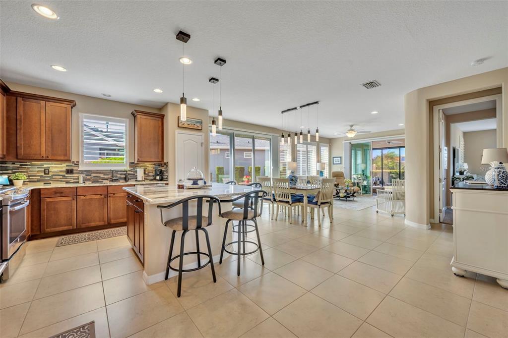 115 Bayou Bend Road Groveland, FL 34736 - Photo 6 of 47 a large dining hall with stainless steel appliances a stove a sink a dining table and chairs