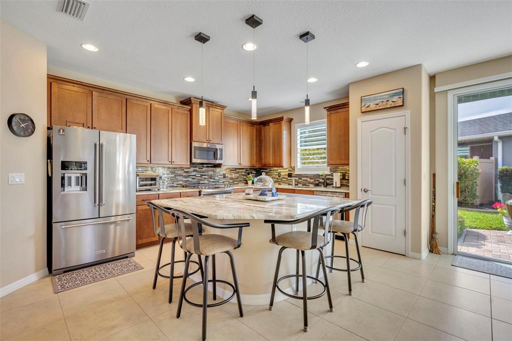 115 Bayou Bend Road Groveland, FL 34736 - Photo 7 of 47 a kitchen with stainless steel appliances granite countertop a sink a stove a refrigerator and a refrigerator with wooden floor
