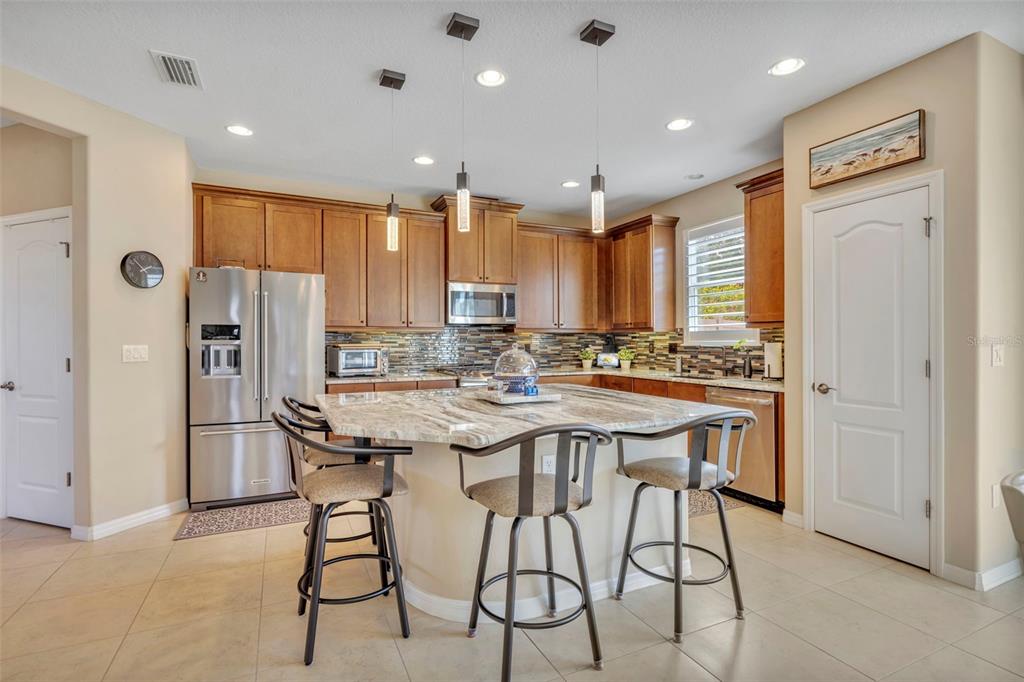 115 Bayou Bend Road Groveland, FL 34736 - Photo 8 of 47 a kitchen with stainless steel appliances kitchen island granite countertop a refrigerator and a stove top oven