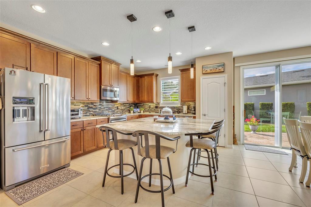 115 Bayou Bend Road Groveland, FL 34736 - Photo 9 of 47 a kitchen with stainless steel appliances a dining table chairs refrigerator and sink