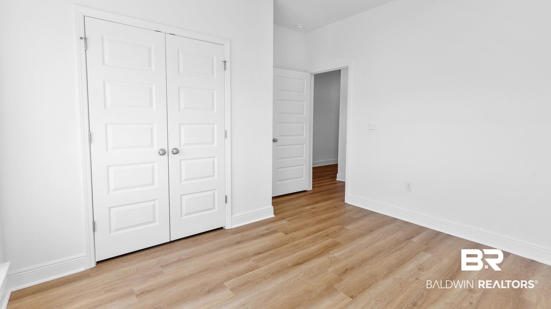 12931 Grand Rpds Road Fairhope, AL 36532 - Photo 8 of 33 Unfurnished bedroom featuring a closet, baseboards, and light wood-style floors