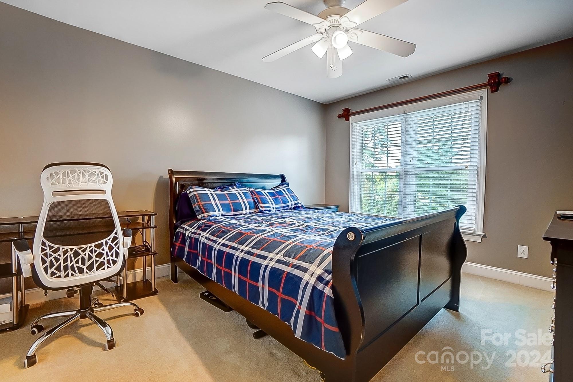 814 Pine Forest Road Charlotte, NC 28214 - Photo 18 of 26 a bedroom with a bed and a chandelier