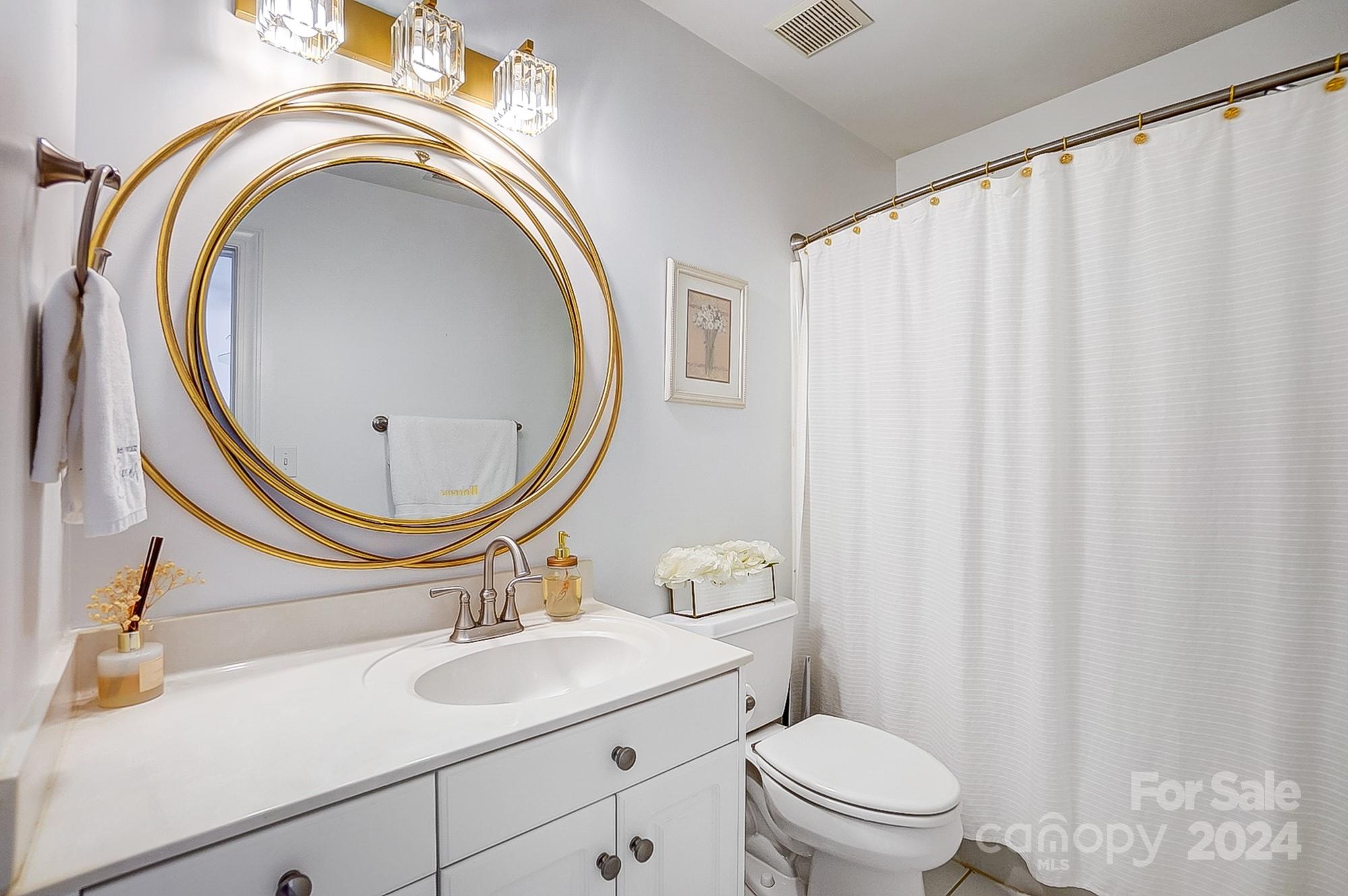 814 Pine Forest Road Charlotte, NC 28214 - Photo 21 of 26 a bathroom with a sink a toilet and a mirror