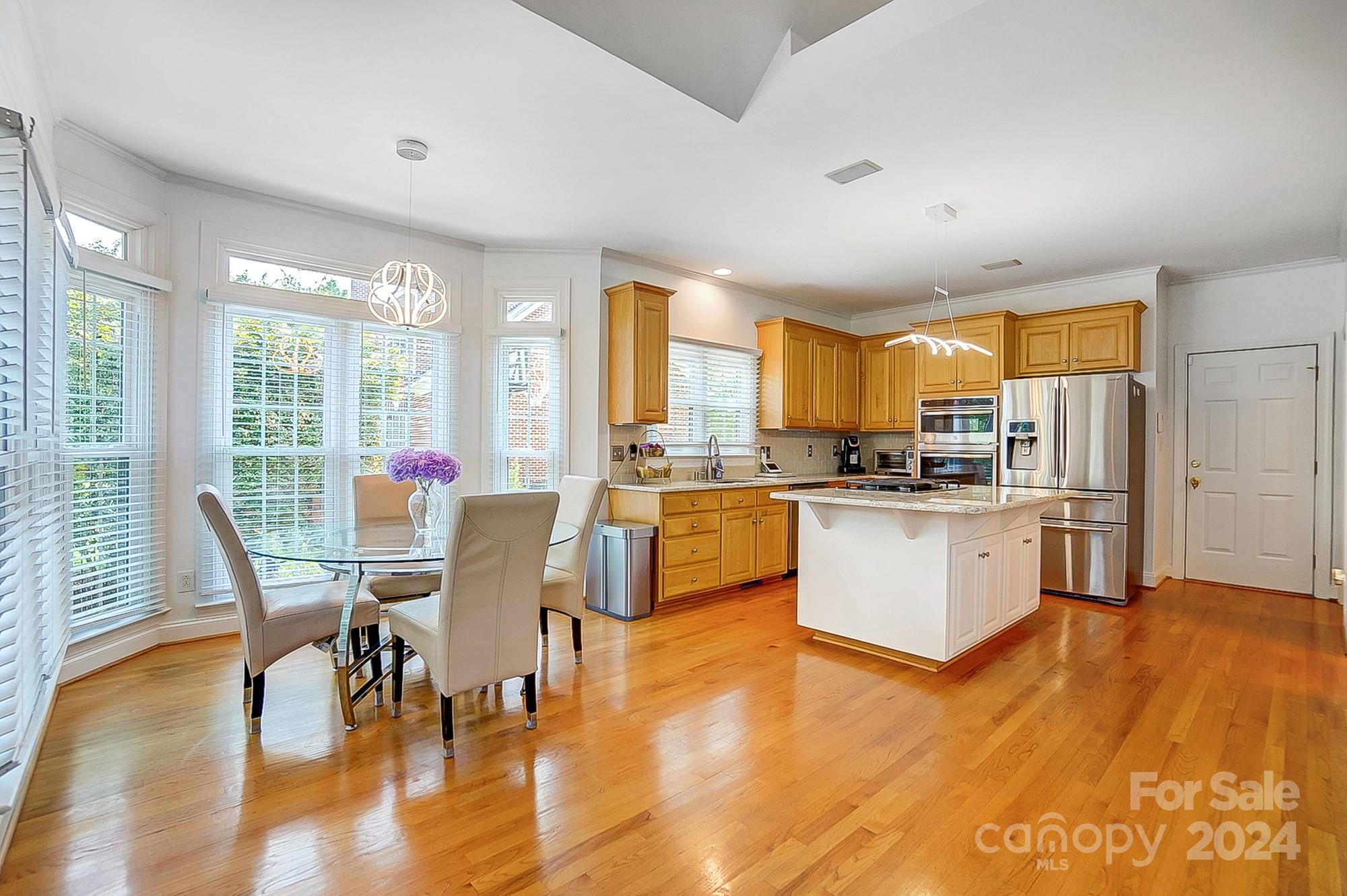 814 Pine Forest Road Charlotte, NC 28214 - Photo 6 of 26 a kitchen with a table chairs refrigerator and cabinets