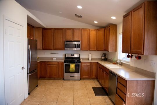 1017 Porter Street Ridgecrest, CA 93555 - Photo 6 of 15 a kitchen with kitchen island granite countertop a sink counter top space appliances and cabinets