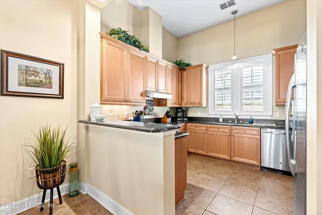 a kitchen with stainless steel appliances granite countertop a stove a sink and a refrigerator