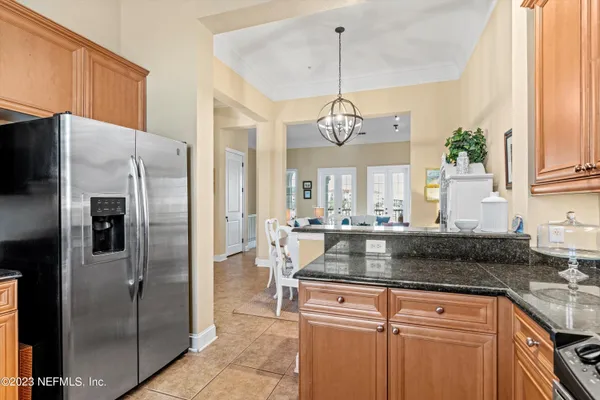 a kitchen with kitchen island granite countertop stainless steel appliances a refrigerator a stove a sink and a center island