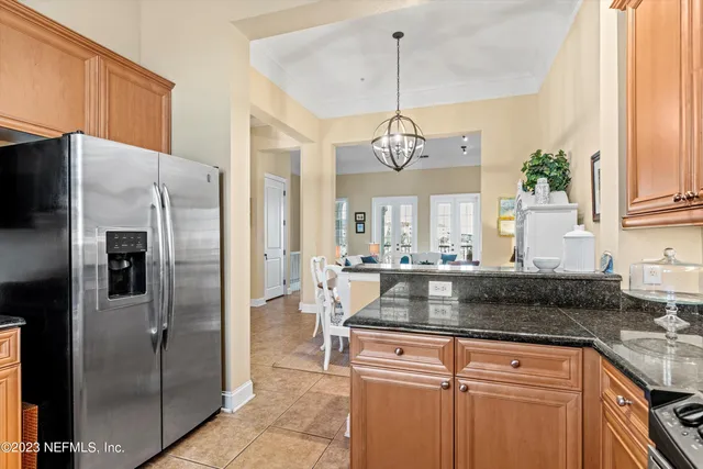 a kitchen with kitchen island granite countertop stainless steel appliances a refrigerator a stove a sink and a center island