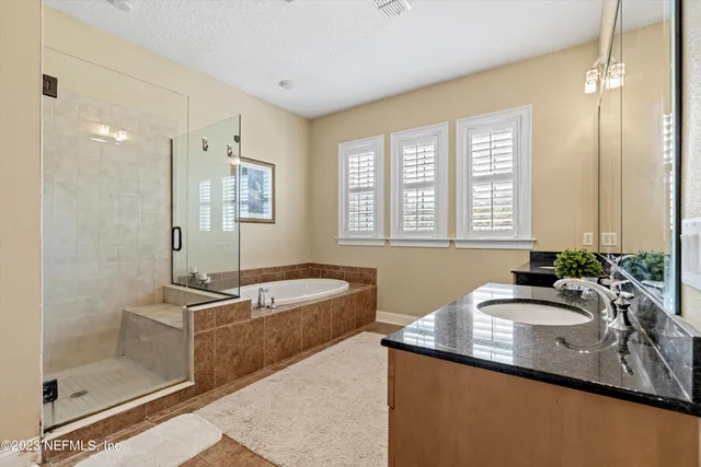 a bath room with a sink double vanity and tub
