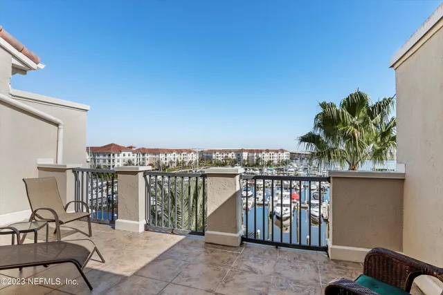 a view of a balcony with chairs and a potted plant