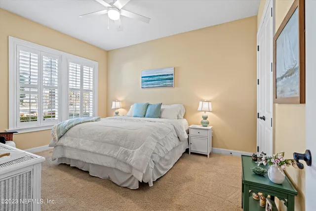 a spacious bedroom with a bed and a chandelier
