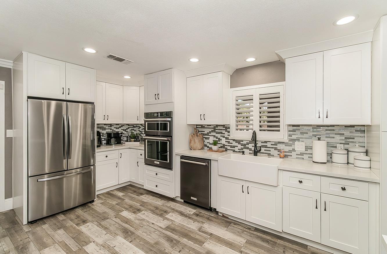 7010 South Frankwood Avenue Reedley, CA 93654 - Photo 14 of 75 a kitchen with white cabinets and stainless steel appliances