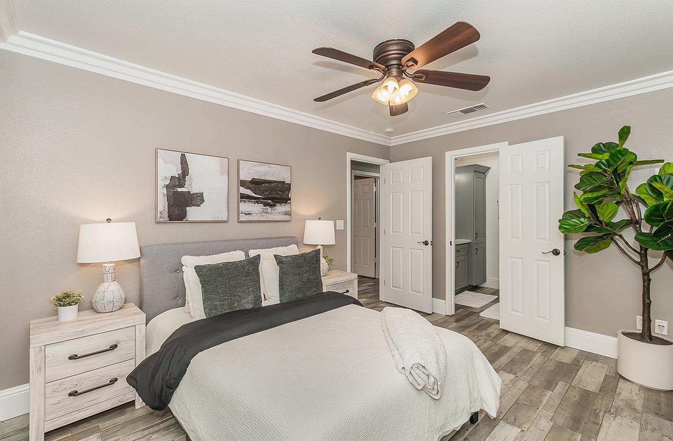 7010 South Frankwood Avenue Reedley, CA 93654 - Photo 27 of 75 a bedroom with a bed and a chandelier