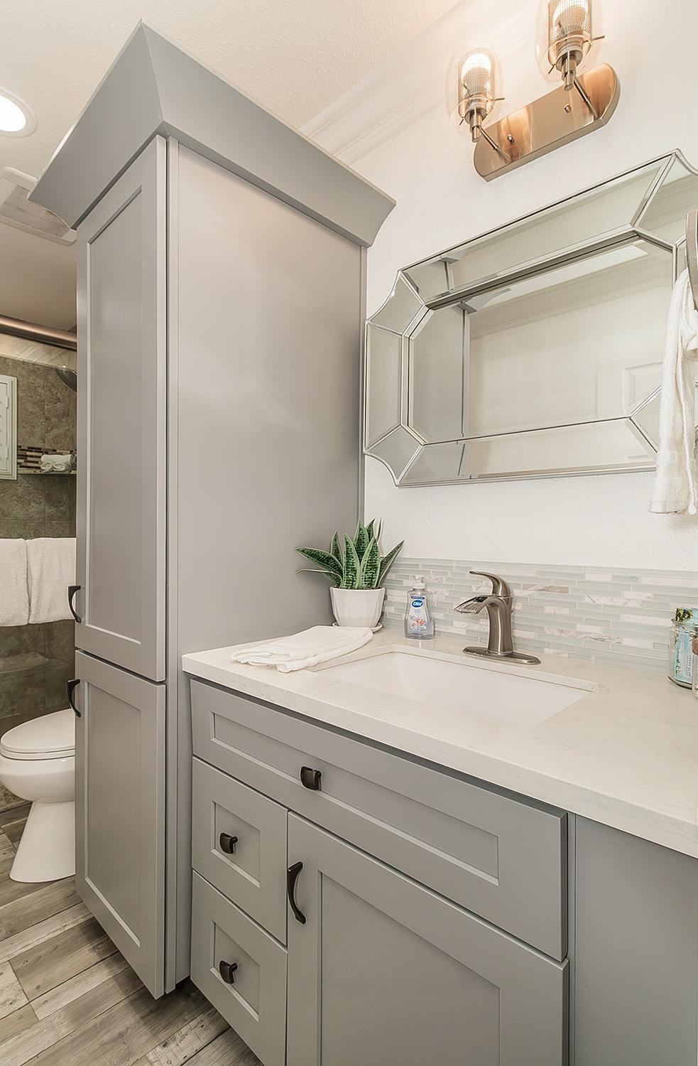 7010 South Frankwood Avenue Reedley, CA 93654 - Photo 32 of 75 a bathroom with a granite countertop sink a toilet and a mirror