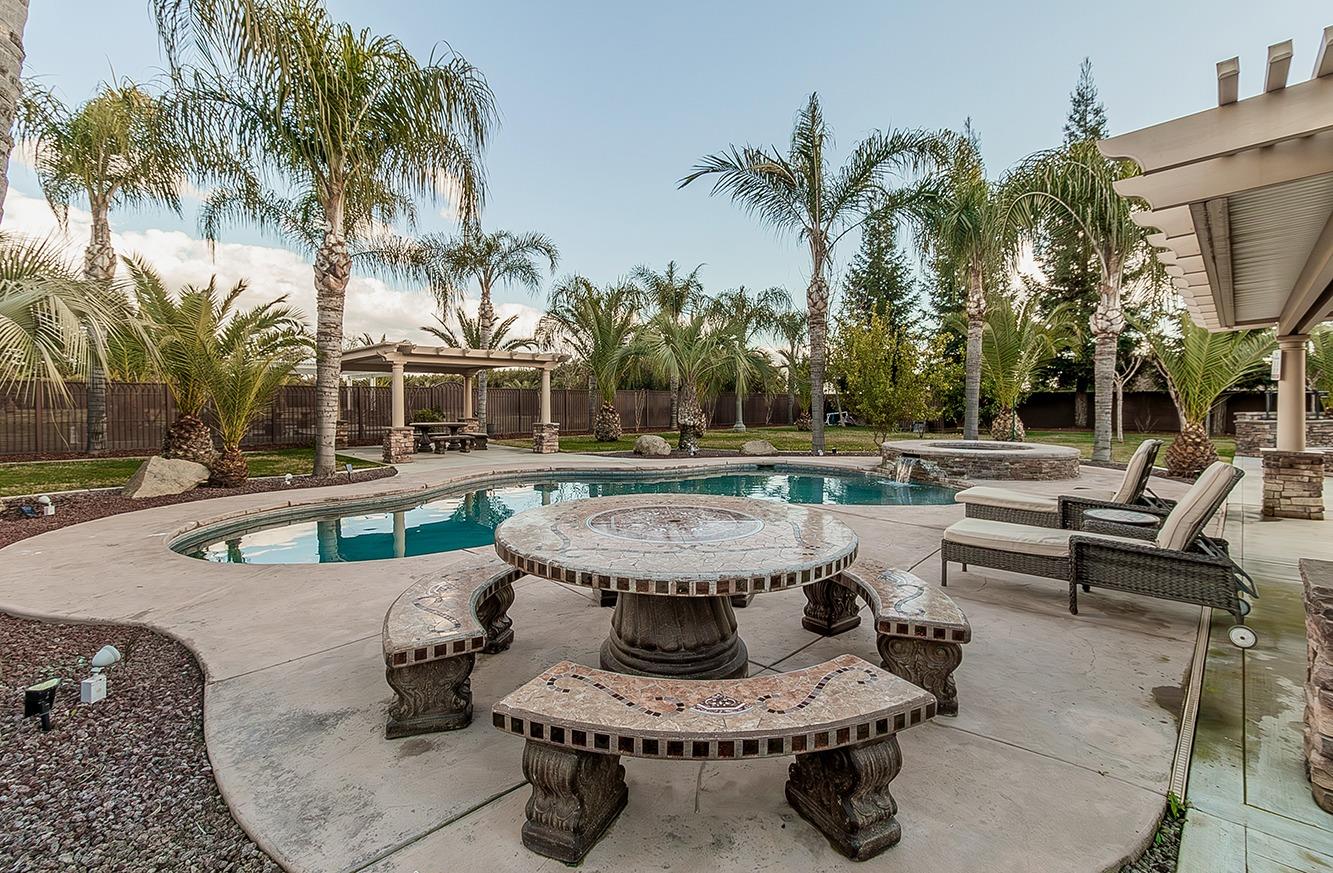 7010 South Frankwood Avenue Reedley, CA 93654 - Photo 40 of 75 a view of a swimming pool with a patio and a fire pit