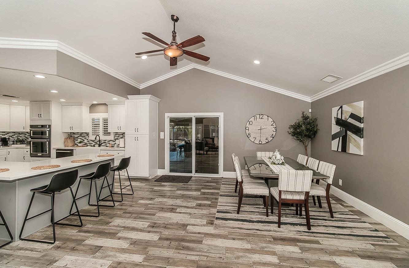 7010 South Frankwood Avenue Reedley, CA 93654 - Photo 9 of 75 a dining room with wooden floor a chandelier a wooden table and chairs