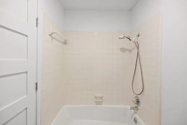 a bathroom with a bath tub with a shower