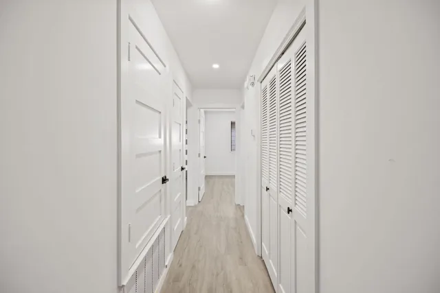 a view of a hallway with wooden floor and staircase