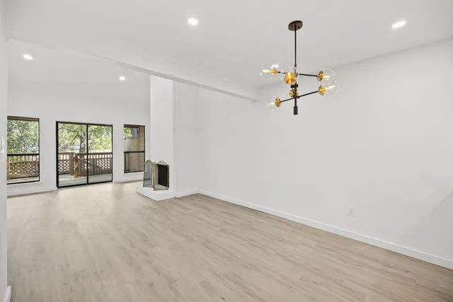 a view of a room with wooden floor ceiling fan and window