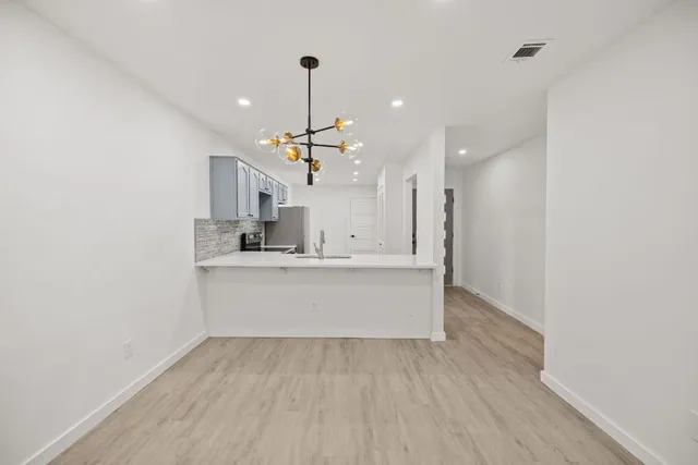 a view of a kitchen with a dishwasher and a wooden floor