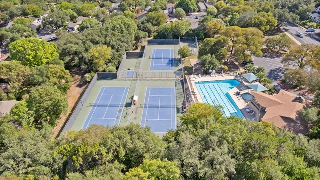 an aerial view of a residential houses with yard