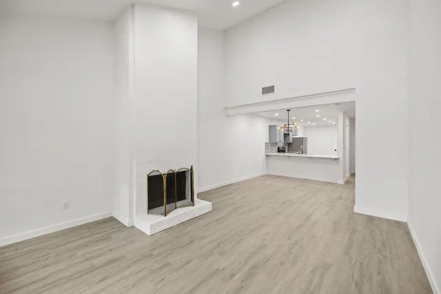 a view of empty room with wooden floor and fireplace