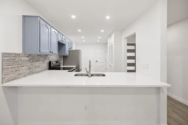 a view of kitchen with stainless steel appliances granite countertop sink