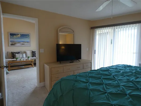a bedroom with a bed and a flat tv screen on dresser