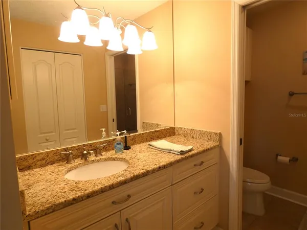 a bathroom with a granite countertop sink and a mirror