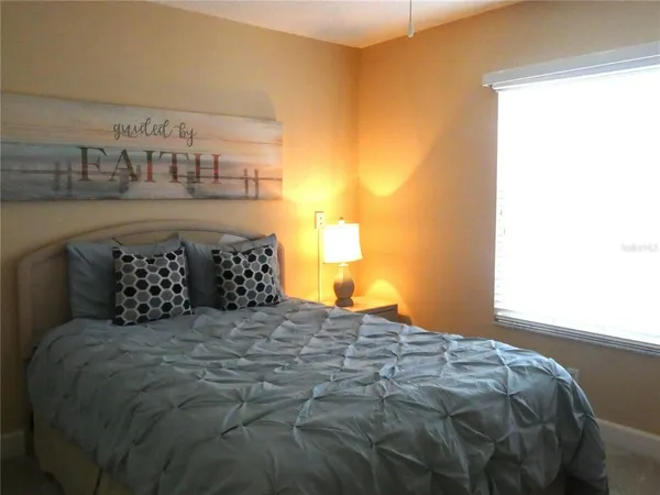 a large bed sitting in a bedroom next to a window